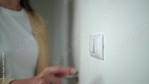 Earth Hour Close up woman finger turn off or on the light to saving electrical energy. Finger pushing light switch turn on or off. White switch.