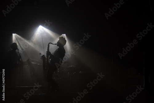 silhouette of a person playing saxophone on the dark stage 
