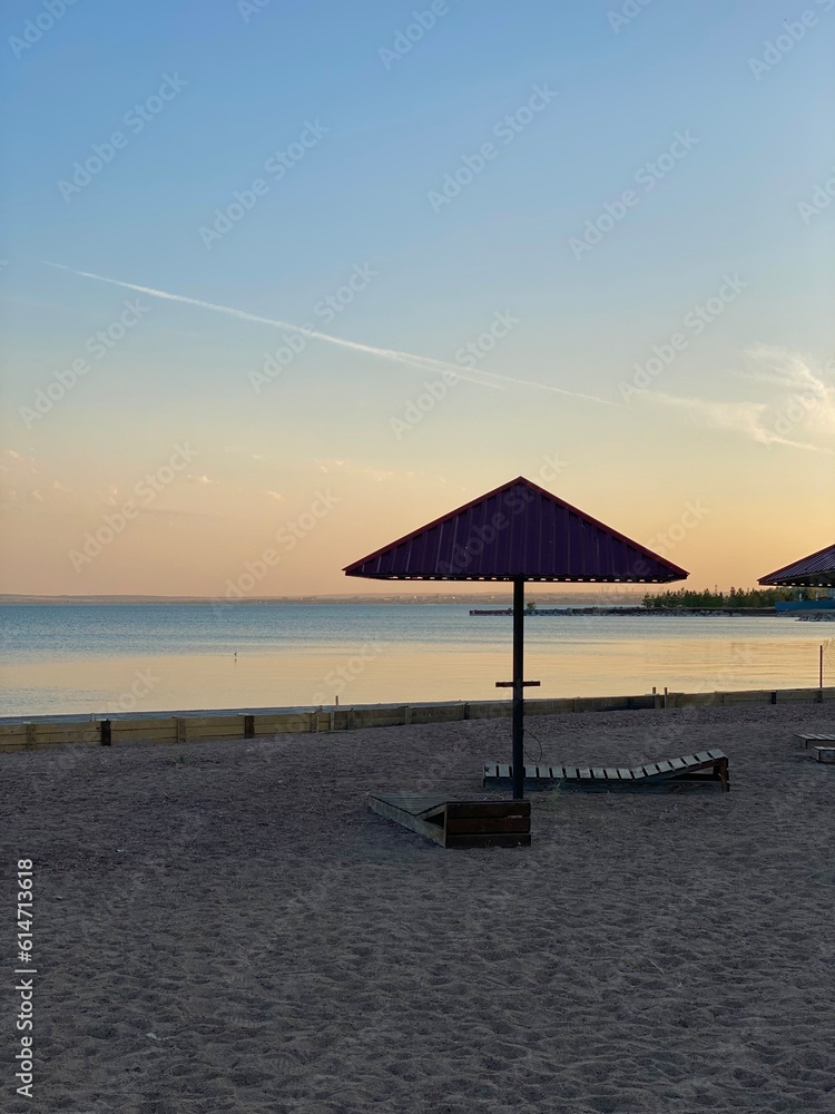 sunset on the beach. Umbrella and sunbed on the sandy beach by the sea. Recreation area, lack of tourists in Turkey.