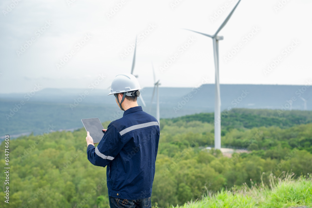 Portrait of engineer asian man working in wind turbine farm.