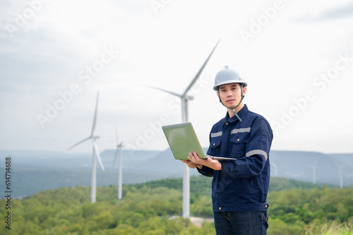 Portrait of engineer asian man working in wind turbine farm.