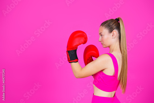 Sportswoman wearing boxing gloves looking at copy space