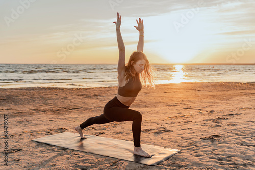 Balance and meditation woman training yoga asana outdoors near the lake. Peace and harmony. The trainer uses an aerobics mat at sunset.