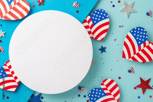 USA Flag Day creative felicitations. Top view of symbolic decorations: hearts featuring flag design, glitter stars, shiny confetti on a pastel blue background with an empty circle for text or advert