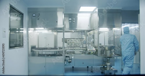 Sterile Pharmaceutical Manufacturing Laboratory where Scientists in Protective Coveralls. Factory Cleanroom. Pharmaceutical, Biotechnological and Semiconductor Creating Manufacturing Process.