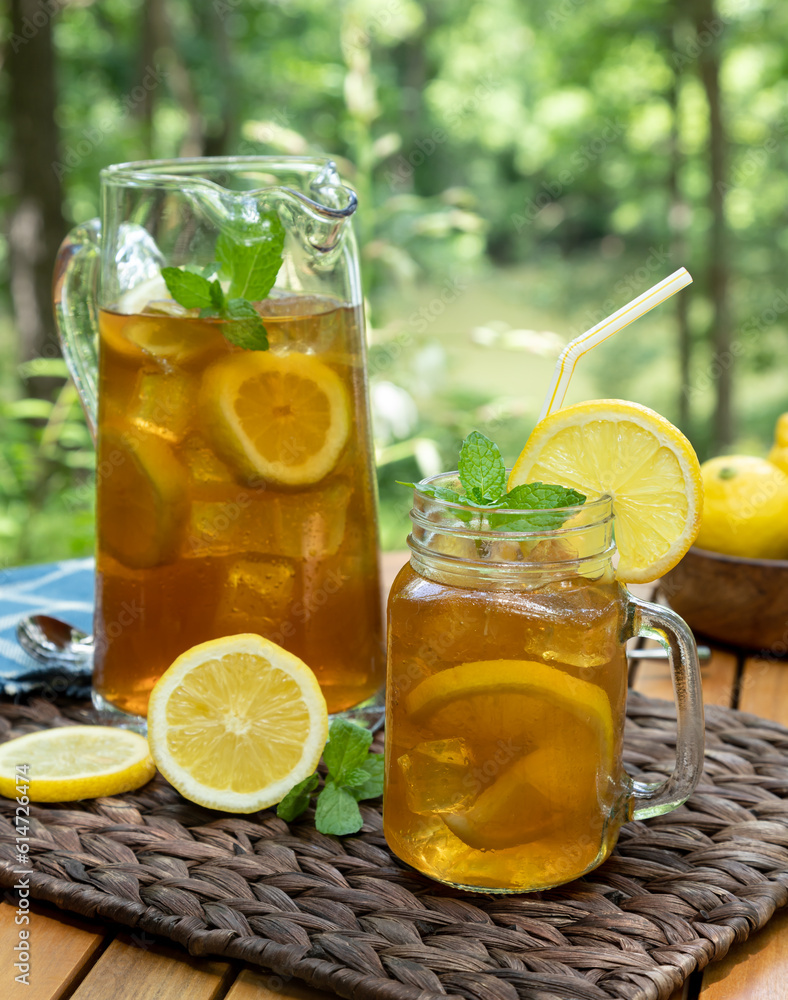 Ice tea in glass jar and pitcher with lemon and mint