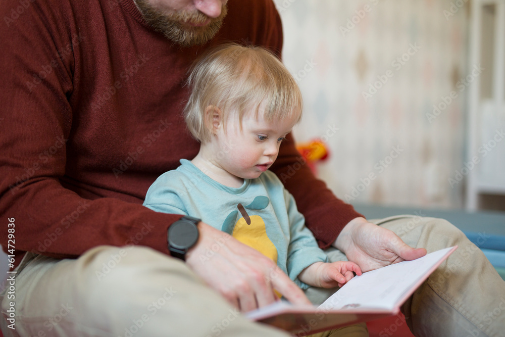 Father reading book to child with down syndrome Father reading book to child with down syndrome