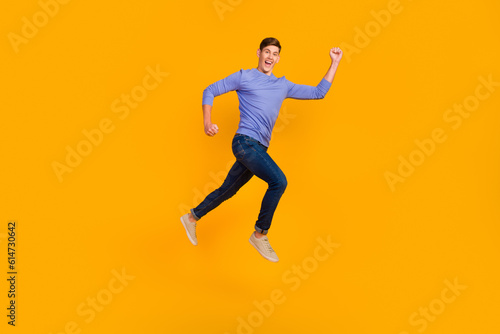 Full length side profile body photo of jumping man run fast rushing wearing casual jeans shirt isolated bright background