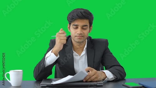 Stressed Indian entrepreneur reading and signing the contract Green screen
