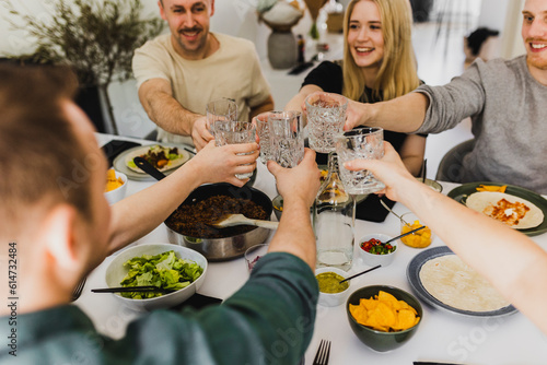 Group of friends raising toast during Mexican feast photo