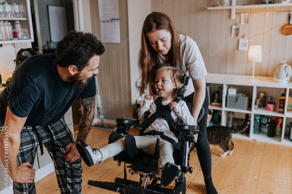 Parents with disabled child in wheelchair at home Parents with disabled child in wheelchair at home