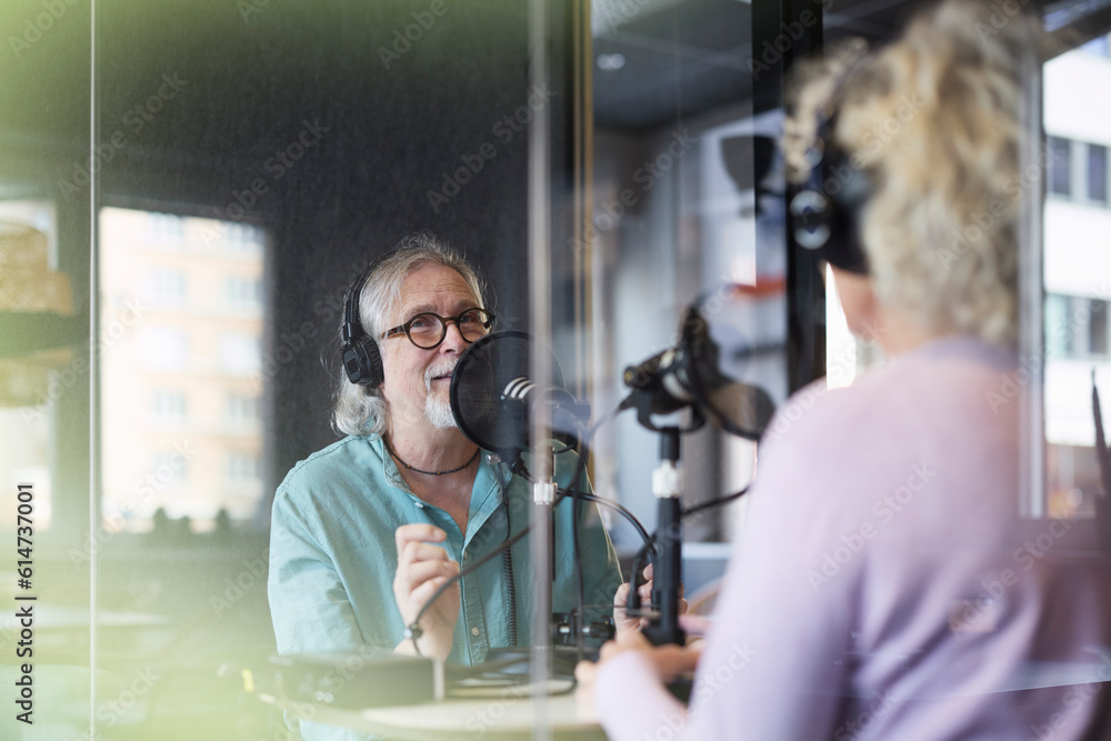 Male radio presenter talking with his guest on radio show or podcast Male radio presenter talking with his guest on radio show or podcast