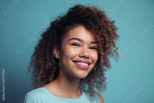Young black female with curly hair in stylish clothes smiling while looking at camera