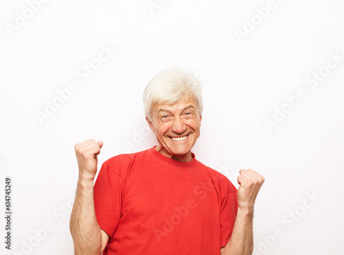 Senior man wearing red t-shirt over isolated background doing happy thumbs up gesture with hands.