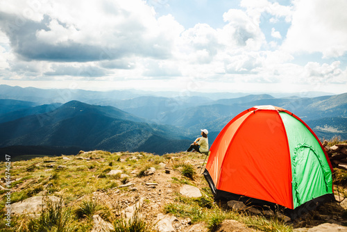 Woman with a tent on top of a mountain