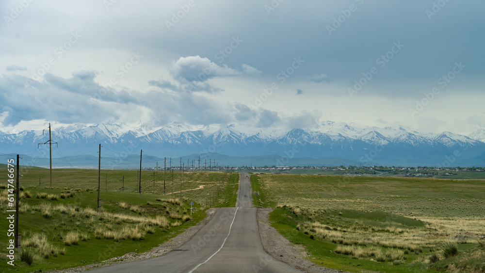 the road through the steppe to the mountains. cloudy weather in the mountains