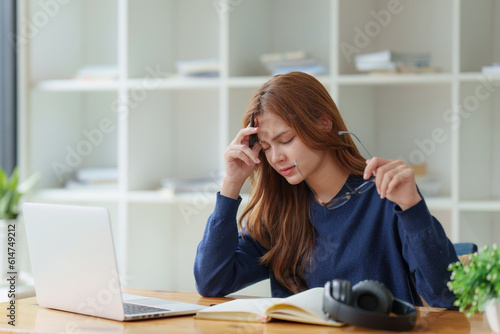 Sad teenager studying preparing for exam test in the university library. Depressed young woman student. Back to School concept