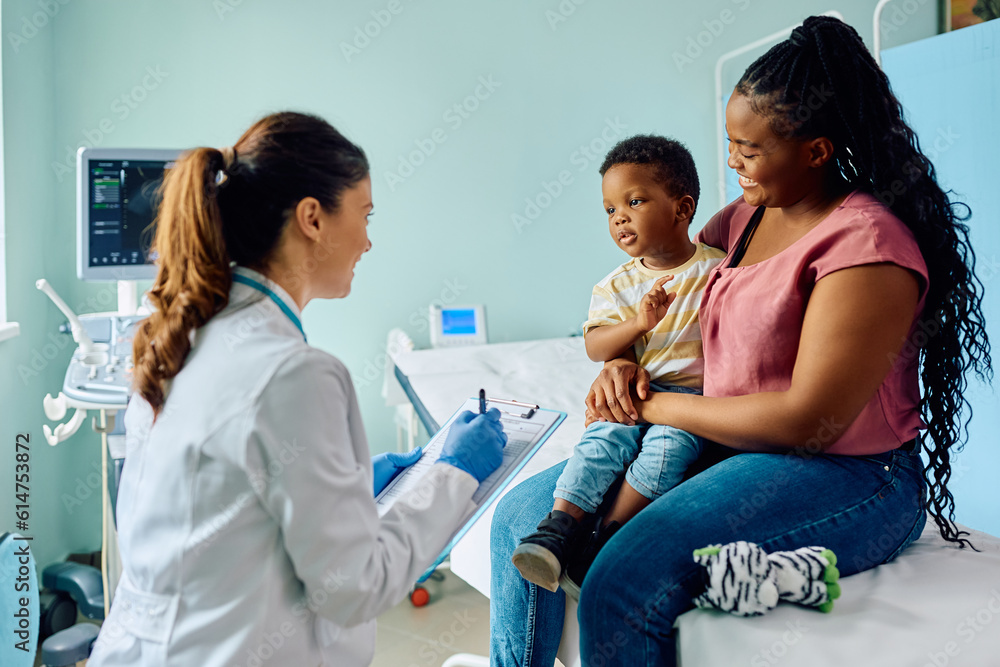 African American boy and his mother talk to female pediatrician at doctor's office. African American boy and his mother talk to female pediatrician at doctor's office.