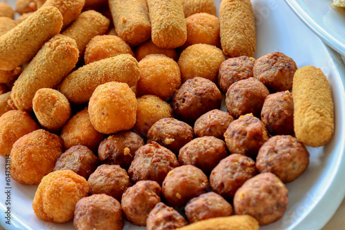 Plate of fried food. Meatballs, potato croquettes, arancini