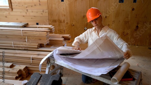 Woman architect reviewing blueprints in a new home construction project survey. photo