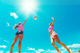 A pair of colorful beach volleyball players jumping to spike the ball against a clear blue sky, flat cinematic view Generative AI