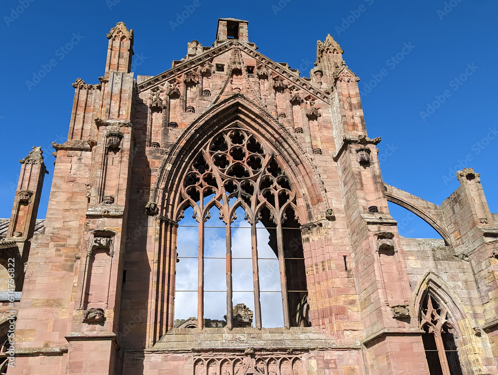 The great East window of the ruined Abbey of St. Mary found in Melrose a town in the Scottish borders in the UK. 