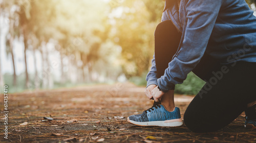 Health and lifestyle concepts, Fitness, Exercising, jogging, running. Asian woman tying her shoes at outdoor park in morning, taking break from exercise.