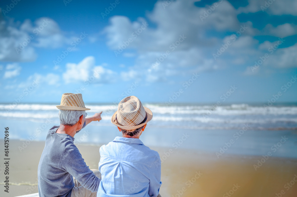 Plan life insurance of happy retirement concepts. Senior couple sitting on chairs at the beach looking the ocean on a good day in sunny day morning.