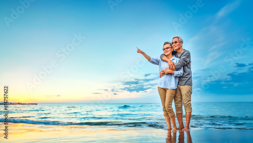 Plan life insurance of happy retirement concepts. Portrait of Senior couple embrace on the beach sunset in evening.