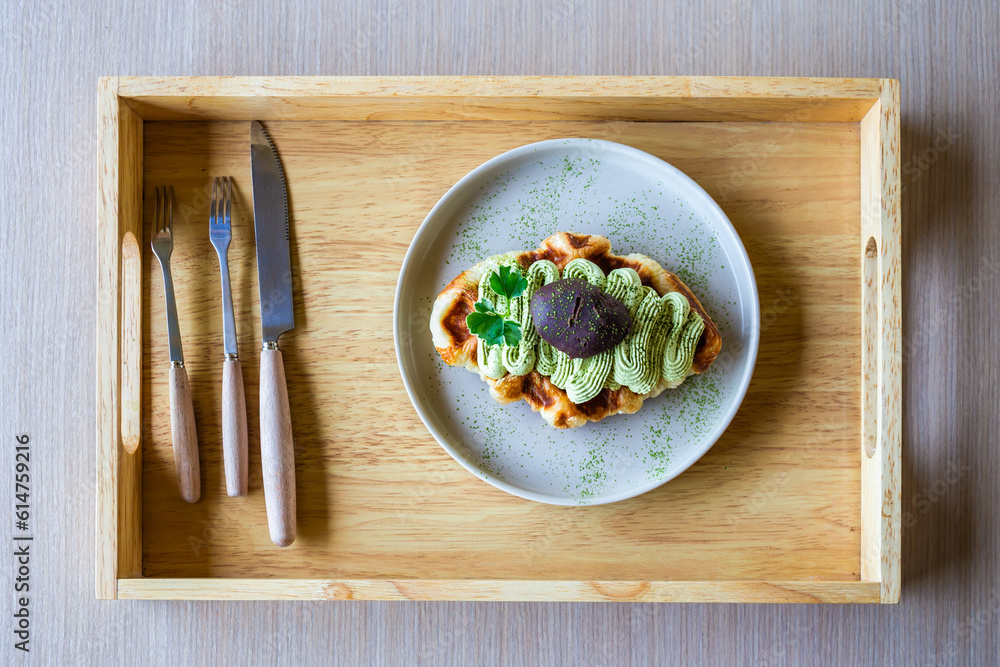 Green tea waffles in a white plate with cutlery and cutlery set on a