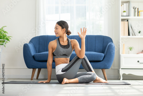 Calm of Asian woman in sportwear stretching muslce to warm up breathing and meditation with yoga at home,Healthy woman doing yoga Feeling so comfortable and relax,Wellness Yoga Healthcare Concept