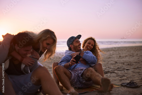 Playful couples hanging out on sunset beach © KOTO