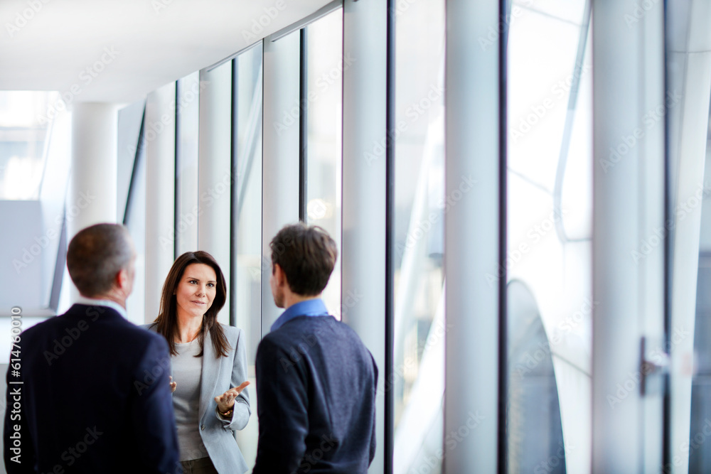 Businesswoman talking to businessmen at office window Businesswoman talking to businessmen at office window
