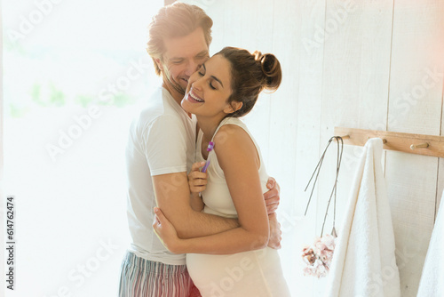 Canvastavla Affectionate pregnant couple hugging in sunny bathroom