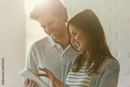 Smiling couple using digital tablet