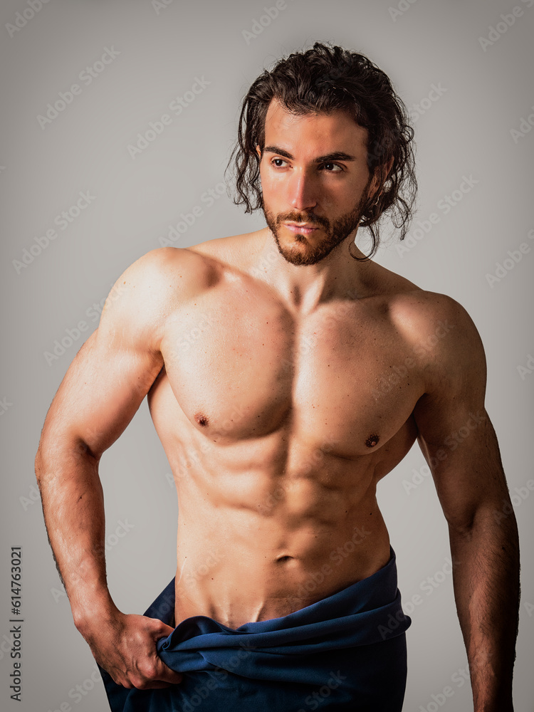 Obraz premium Naked muscular man covering crotch with towel