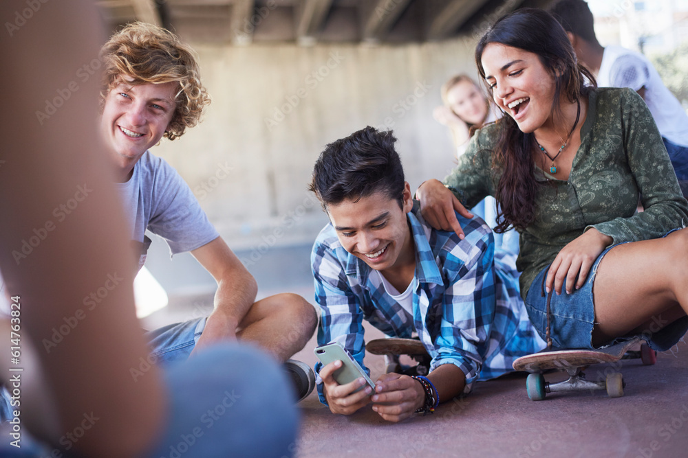 Teenage friends hanging out texting with cell phone at skate park Teenage friends hanging out texting with cell phone at skate park