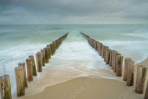 Wooden breakwater poles in the waves of the nord sea