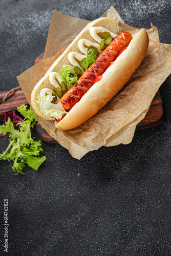 hot dog sandwich sausage, gherkin, ketchup, mayonnaise fast food smeal food snack on the table copy space food background rustic top view photo