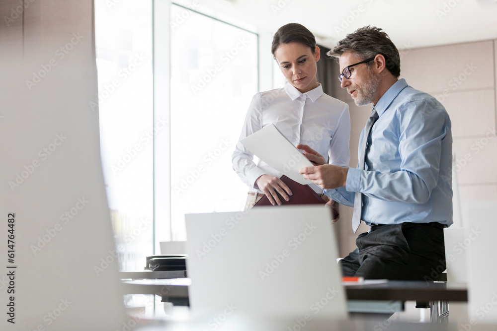 Businessman and businesswoman reviewing paperwork Businessman and businesswoman reviewing paperwork