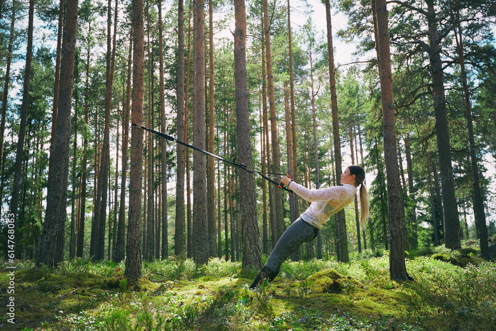 Runner using resistance band on tree in woods Runner using resistance band on tree in woods