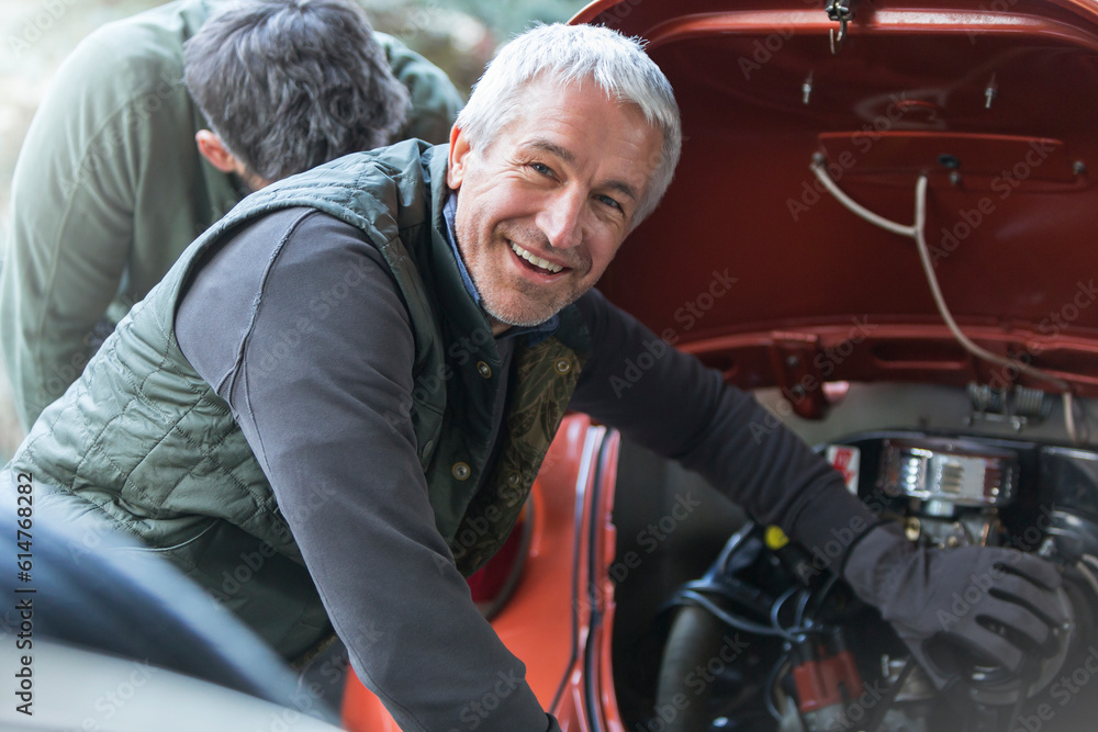 Portrait smiling mechanic fixing engine in auto repair shop - obrazy, fototapety, plakaty 