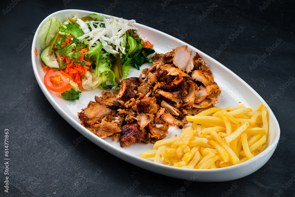 Chicken meat with french fries and a salad of pickled cucumbers, tomatoes, carrots, lettuce and parsley, shawarma without lavash.