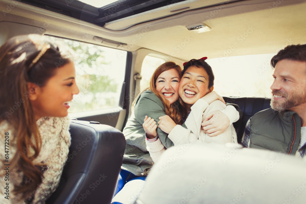 Enthusiastic female friends hugging in back seat of car Enthusiastic female friends hugging in back seat of car