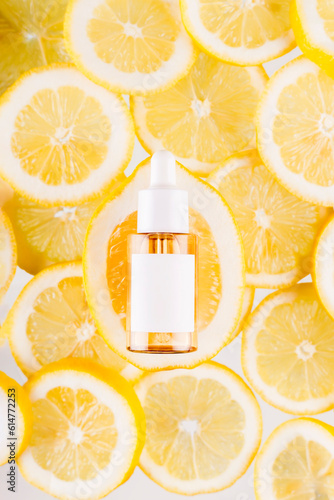 Vitamin C formula ampoule. Serum in transparent bottle with lemon flat lay on skice of lemons bright yellow background. Beauty and health concept. Mockup for your design with copy space.. photo