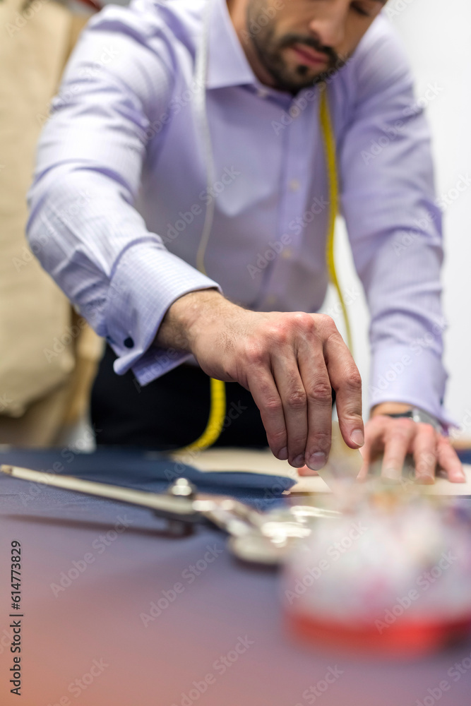 Tailor marking fabric in menswear workshop Tailor marking fabric in menswear workshop