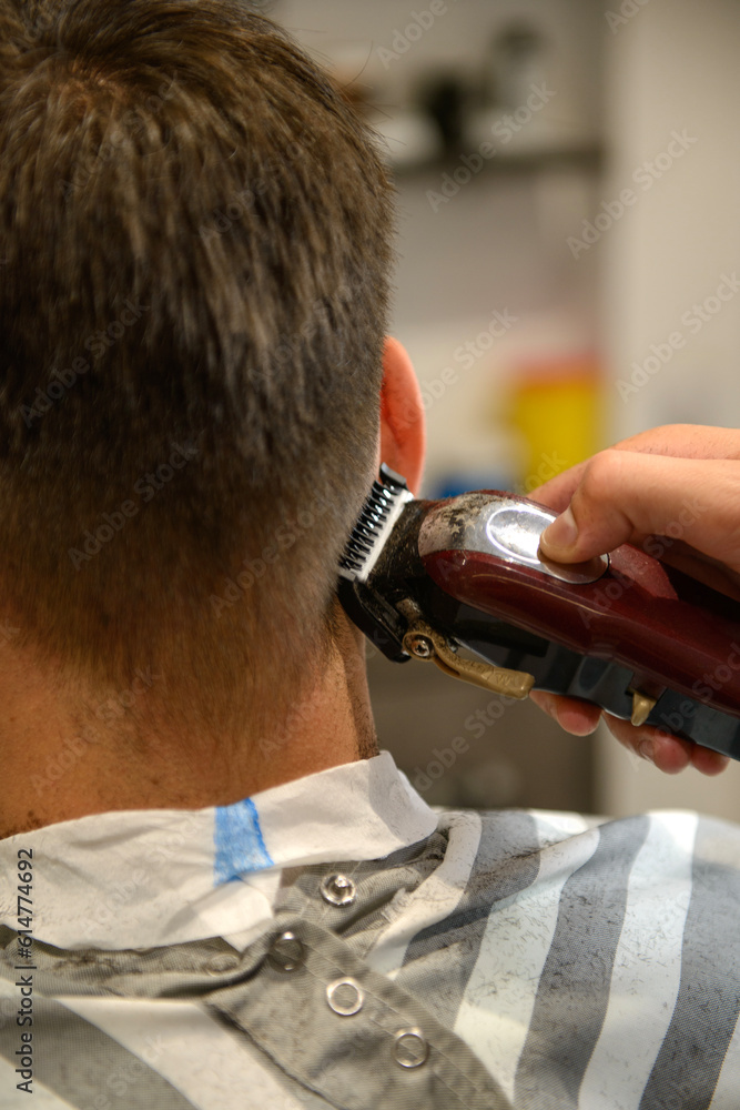 Man getting a haircut with an electric shaver at the barber