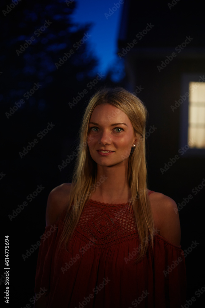 Fototapeta premium Portrait smiling woman in dark backyard