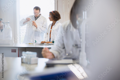 College students conducting scientific experiment in science laboratory classroom