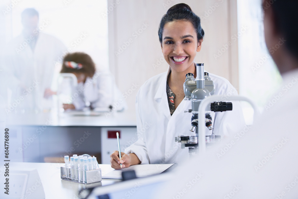 Smiling female college student conducting scientific experiment in science laboratory classroom Smiling female college student conducting scientific experiment in science laboratory classroom